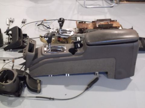 1999 Mercury Grand Marquis - The center console and shifter assembly from a vehicle have been removed and laid out on the floor.