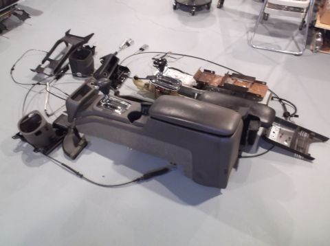 1999 Mercury Grand Marquis - Car center console components laid out on the floor, including shifter and armrest.