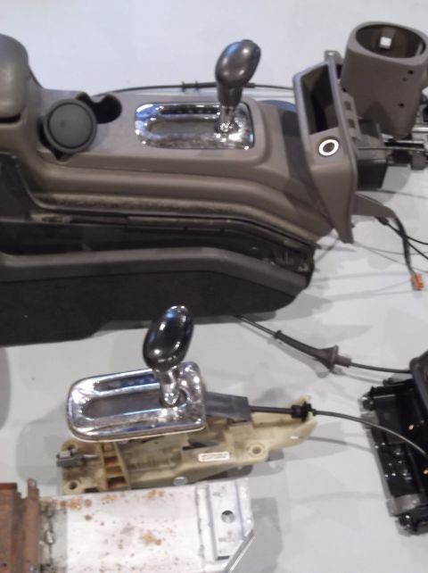 1999 Mercury Grand Marquis - Disassembled car interior components, including center consoles and gear shift mechanisms, are laid out.