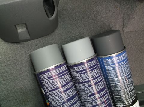 1999 Mercury Grand Marquis - Spray paint cans sit on the carpeted floor of a vehicle's interior.