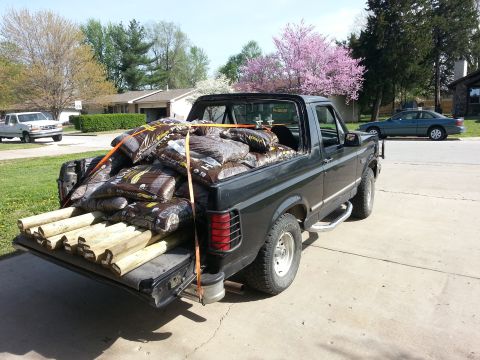 1994 Ford Bronco - This black Ford Bronco is loaded with soil bags and lumber, parked in a driveway.