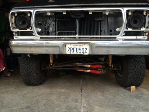 1978 Ford Bronco - The front end of a Ford truck is shown, missing its grille and headlights, revealing the radiator and suspension components.