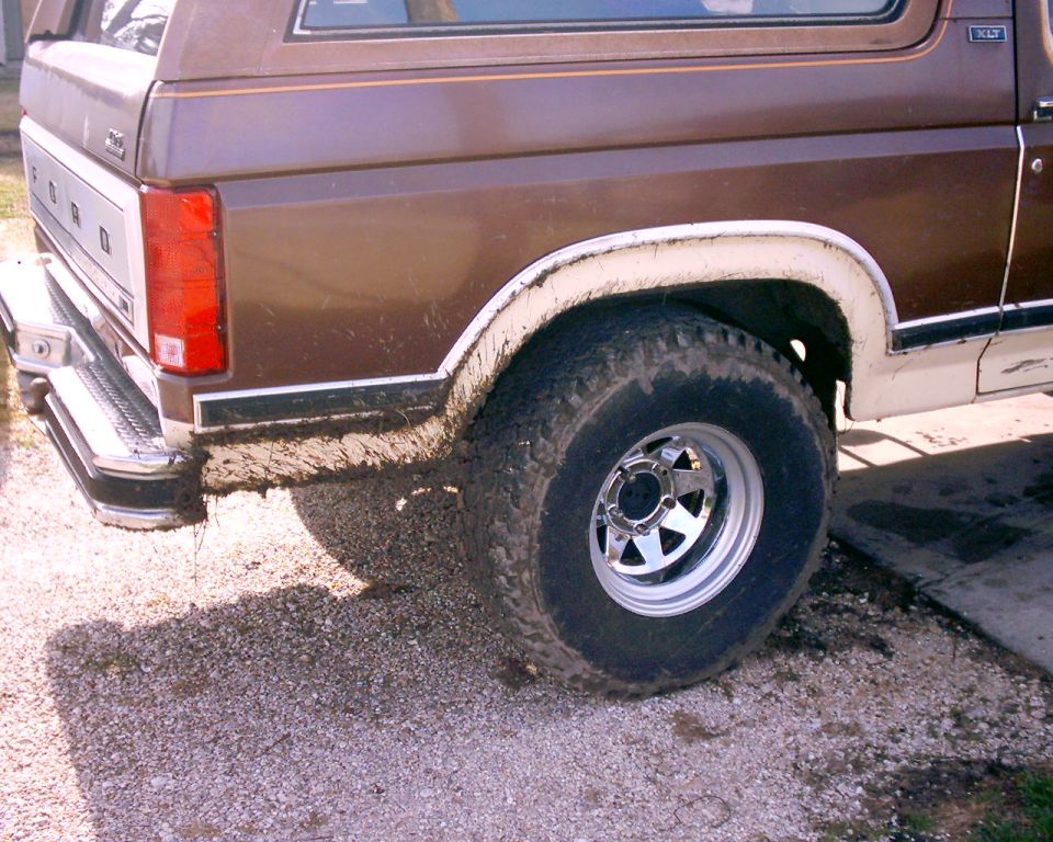 1980 Ford Bronco rear quarter panel and tire covered in mud