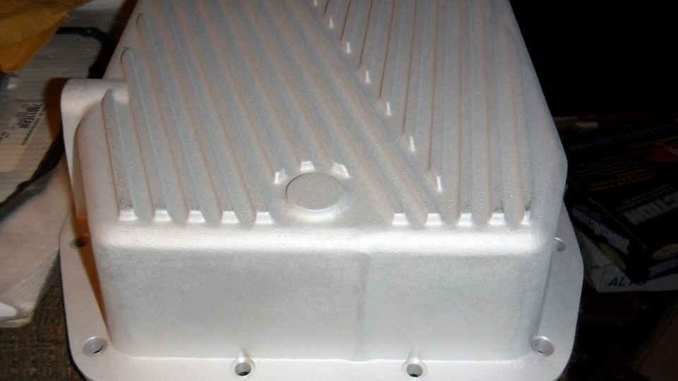 Aluminum transmission pan with cooling fins and bolt holes