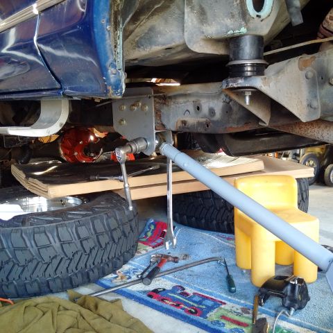 1978 Ford Bronco - Close-up view of vehicle suspension work with tools laid out on a rug.