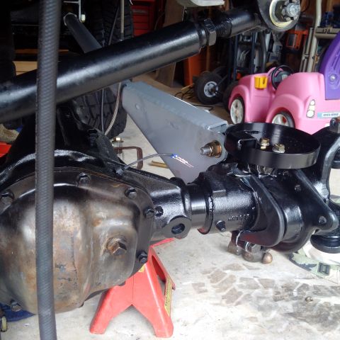 1978 Ford Bronco - Close-up of vehicle suspension components, with toy vehicles in the background.