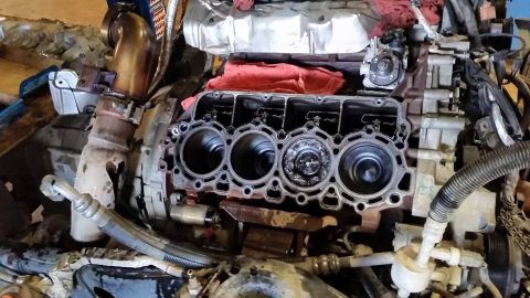 1986 Ford Bronco - Close-up of an engine block with cylinders visible, part of a larger mechanical assembly.