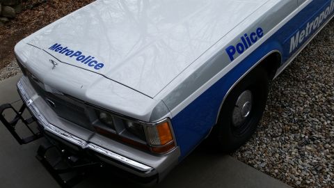 1991 Ford LTD Crown Victoria - Front view of a 1991 Ford Crown Victoria LTD police car, showing the hood and fender with markings.