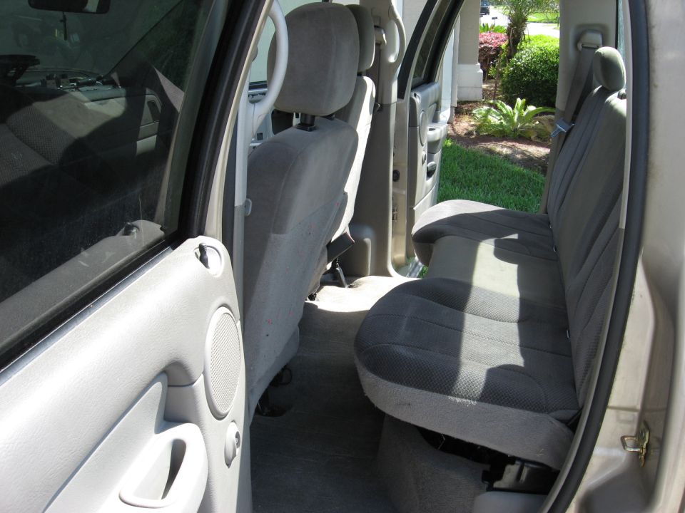 Gray cloth rear seats and interior door panel of a truck. Sunlight streams through the windows