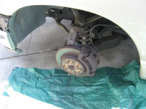 1994 Ford Bronco - Close-up of a vehicle's front wheel brake assembly, showing the rotor and caliper.