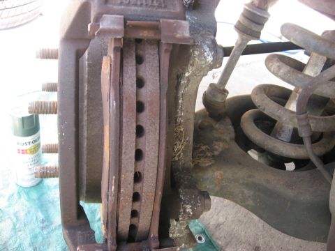 1994 Ford Bronco - This image shows a close-up view of a vehicle's brake assembly, including the caliper, pads, and rotor.
