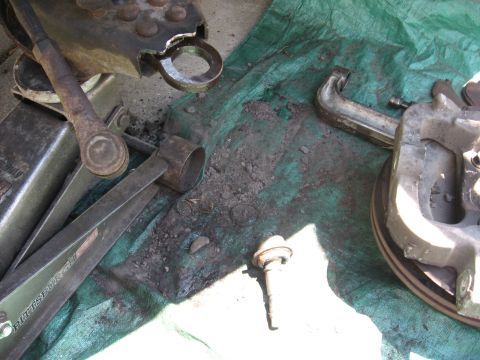 1994 Ford Bronco - Various automotive parts and tools are laid out on a green tarp, suggesting a repair or maintenance session.