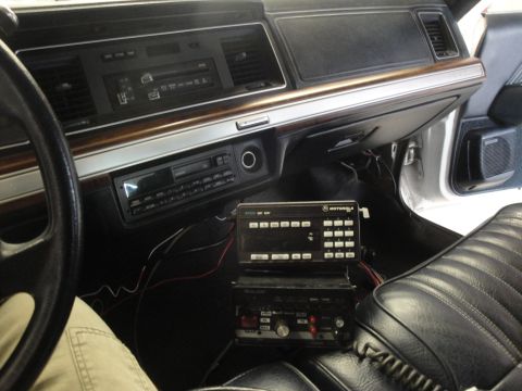 1991 Ford LTD Crown Victoria - The interior of a police vehicle shows a dashboard equipped with Motorola two-way radios and a CB radio unit.