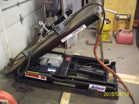 1969 Ford Torino - Close-up of a hydraulic lift's internal components, including a motor and cylinder, with various labels visible.
