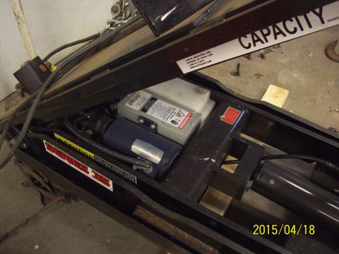 1969 Ford Torino - Close-up view of a hydraulic lift's internal components, including a motor and reservoir.