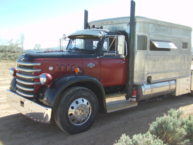 Red and black semi-truck, 3q-front view, with silver trailer