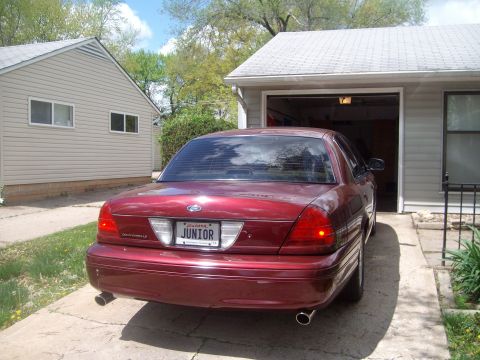 2004 Ford Crown Victoria - This 2004 Ford Crown Victoria is seen from the rear, parked in a driveway next to a garage.