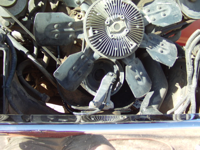 Engine fan with metal blades and a ribbed pulley system, chrome bumper below