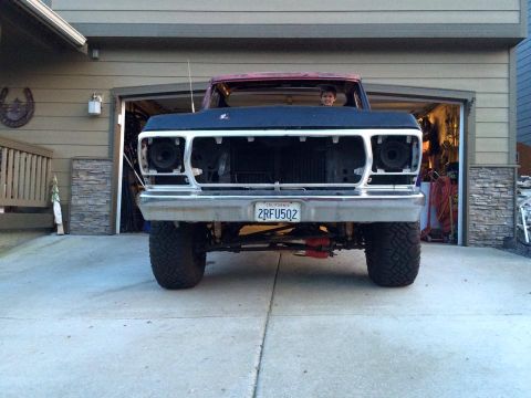 1978 Ford Bronco - This lifted Ford truck is missing its grille and headlights, showing its engine bay from the front.