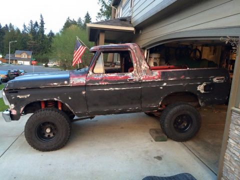 1978 Ford Bronco - This 1978 Ford Bronco, seen from the side, features a lifted suspension and a weathered black and red paint job.