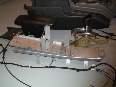 1999 Mercury Grand Marquis - Disassembled car interior components, including the gear shifter and console frame, are laid out on the floor.