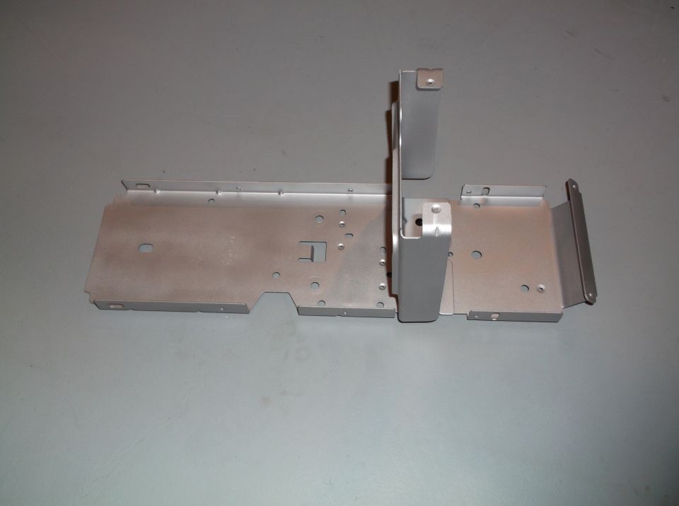 Metal bracket assembly with various holes and mounting points, likely for undercarriage or interior component