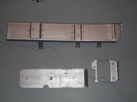 1999 Mercury Grand Marquis - Unidentified metal automotive parts are laid out on a gray surface.