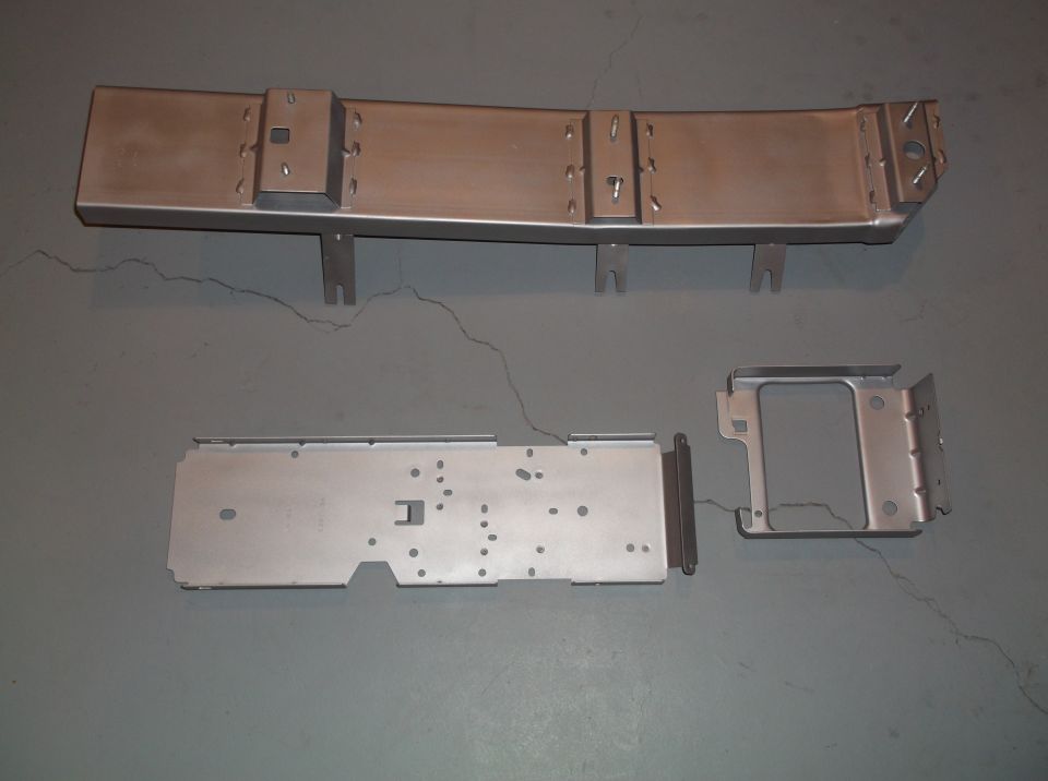 Metal console parts laid out on a gray floor