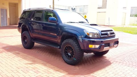 2005 Toyota 4Runner - This dark blue SUV has a hood scoop and aftermarket wheels, suggesting a model year later than 2005.