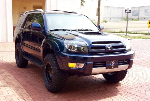 2005 Toyota 4Runner - Front 3/4 view of a dark blue 2005 Toyota 4Runner SUV with aftermarket wheels.