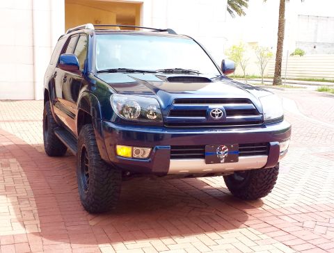 2005 Toyota 4Runner - A dark blue 2005 Toyota 4Runner is parked on a brick driveway, facing the camera.