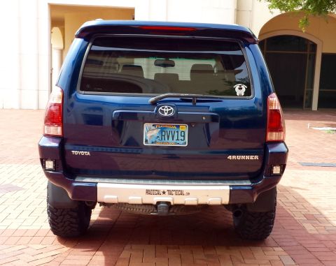 2005 Toyota 4Runner - Rear view of a blue 2005 Toyota 4Runner, a custom bumper with "RADICAL TACTICAL" text.