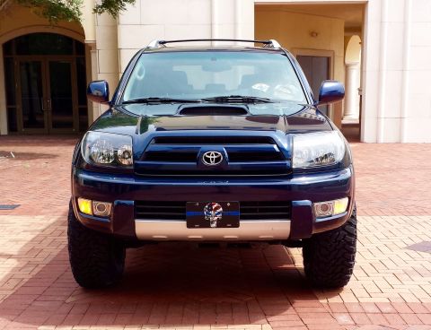 2005 Toyota 4Runner - Front view of a blue 2005 Toyota 4Runner, a prominent hood scoop and aftermarket wheels.
