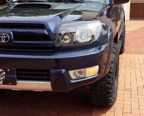 2005 Toyota 4Runner - Front quarter view of a dark blue 2005 Toyota 4Runner, aftermarket tires and a custom license plate.