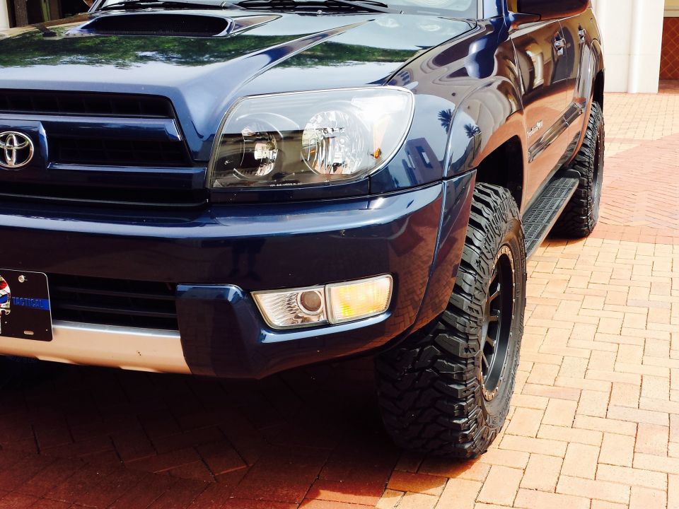Front corner of a dark blue 2005 Toyota 4Runner with aftermarket tires
