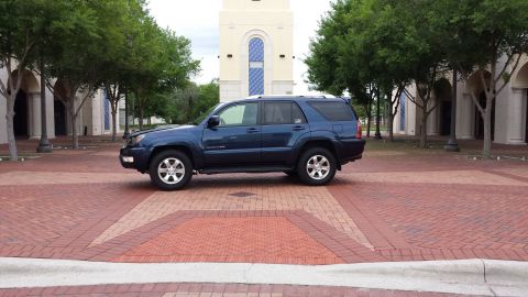 2005 Toyota 4Runner - Side view of a blue 2005 Toyota 4Runner parked on a brick surface.