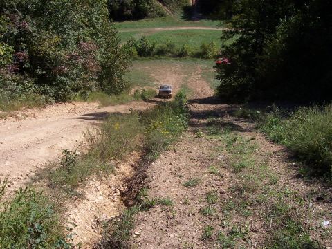 1978 Ford Bronco - A white 1978 Ford Bronco navigates a steep dirt incline, with another vehicle in the distance.