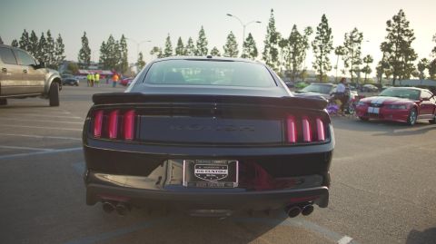 1995 Ford Taurus - Rear view of a black Ford Mustang with Roush badging, parked at an outdoor car show.