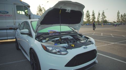 1995 Ford Taurus - A white Ford Focus ST is displayed with its hood open, parked next to a Ford Racing truck.