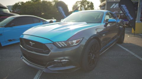 1995 Ford Taurus - A Ford Mustang is parked at an outdoor event, with another car visible to its left.