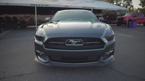 1995 Ford Taurus - Front view of a dark gray Ford Mustang parked under a tent with a Nitto banner.