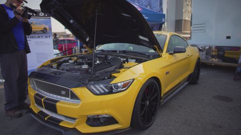 1995 Ford Taurus - A yellow Ford Mustang Shelby GT is displayed with its hood open, revealing the engine bay.