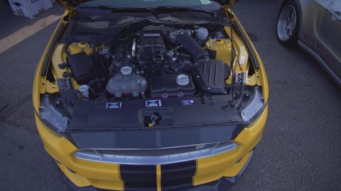 1995 Ford Taurus - Yellow Ford Mustang engine bay with aftermarket supercharger visible.