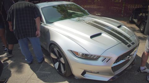 1995 Ford Taurus - A silver Ford Mustang with racing stripes and '725' on the hood is displayed at an outdoor event.