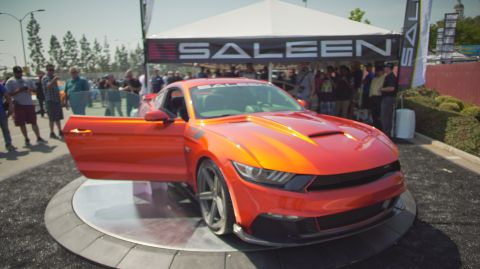 1995 Ford Taurus - Orange Saleen Mustang displayed at an event with the Saleen tent visible.