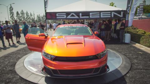 1995 Ford Taurus - A bright orange Saleen Mustang is showcased with its door open, under a Saleen branded tent.