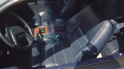 1995 Ford Taurus - The interior features blue leather seats with a wood-accented center console and dashboard.