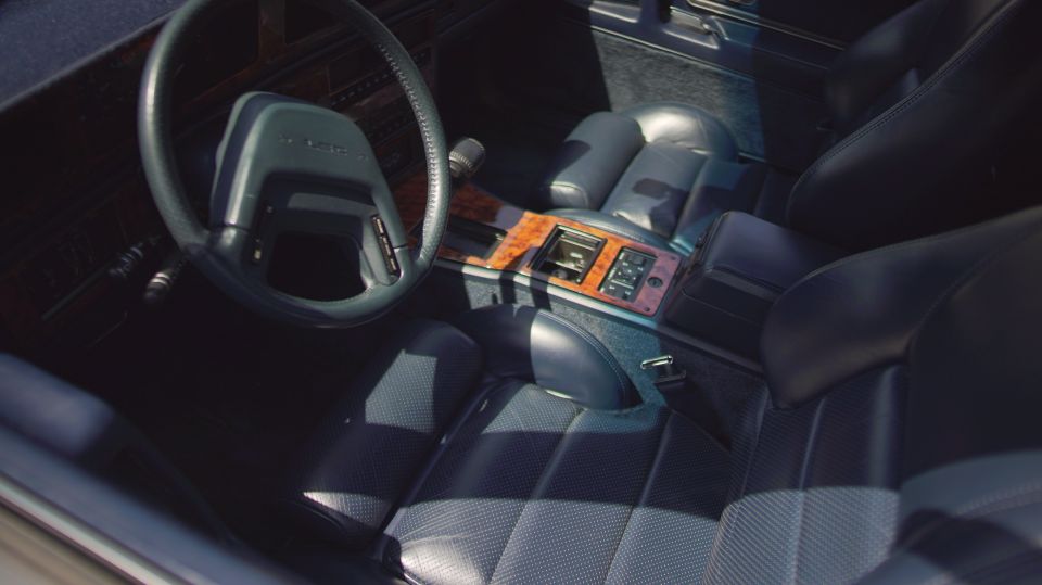 Dark blue interior with leather seats, wood trim center console, and steering wheel