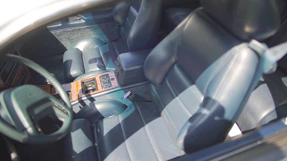 1995 Ford Taurus interior with dark blue leather seats, wood trim, and a steering wheel