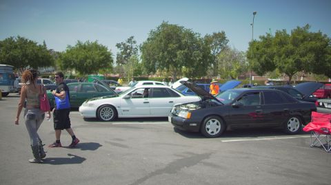 1995 Ford Taurus - A black 1995 Ford Taurus sedan is displayed with its hood open at a car show event.